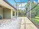 A spacious, screened-in patio featuring brick flooring and an extended seating area at 567 Villa Park Rd, Kissimmee, FL 34759