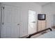 Cozy bedroom features a view into the bathroom, light wood dresser, and large tv at 624 Montana Ave, Davenport, FL 33897