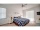 Bright bedroom features large windows with white blinds, stylish blue patterned bedspread, and a modern ceiling fan at 624 Montana Ave, Davenport, FL 33897