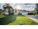 Inviting single-story home with a well-manicured lawn and mature palm tree in a sunny setting at 624 Montana Ave, Davenport, FL 33897