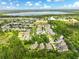Expansive aerial view showcasing the neighborhood, nearby lake, and lush greenery creating a serene environment at 6886 Sundrop St, Harmony, FL 34773
