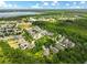 Panoramic aerial view of a thriving community, with a serene lake, surrounded by lush greenery and well-maintained homes at 6886 Sundrop St, Harmony, FL 34773