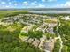 Expansive aerial view showcasing the neighborhood, nearby lake, and lush greenery creating a serene environment at 6886 Sundrop St, Harmony, FL 34773
