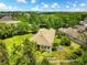 Aerial view of a landscaped backyard featuring a fire pit area, manicured lawn, and lush greenery at 6886 Sundrop St, Harmony, FL 34773