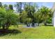 Backyard features lush lawn, palm trees and white picket fence at 6886 Sundrop St, Harmony, FL 34773