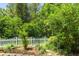 Charming backyard garden with a white picket fence and lush greenery at 6886 Sundrop St, Harmony, FL 34773