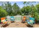 Charming backyard featuring colorful Adirondack chairs and a white picket fence at 6886 Sundrop St, Harmony, FL 34773