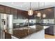 Modern kitchen with dark cabinets, granite countertops, and stainless appliances at 6886 Sundrop St, Harmony, FL 34773