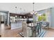Eat-in kitchen with breakfast bar, dark cabinets, granite countertops, stainless steel appliances, and stylish dining table at 6886 Sundrop St, Harmony, FL 34773