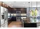 Spacious kitchen featuring dark cabinets, granite counters, and stainless appliances at 6886 Sundrop St, Harmony, FL 34773