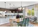 Open kitchen/dining area with dark cabinets and stainless steel appliances at 6886 Sundrop St, Harmony, FL 34773
