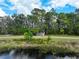 Scenic nature trail featuring a wooden bridge over a pond, surrounded by lush trees at 6886 Sundrop St, Harmony, FL 34773