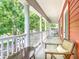 Relaxing balcony with tall white columns and furniture perfect for enjoying the scenic neighborhood views at 715 Honeysuckle Ave, Celebration, FL 34747
