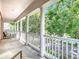 Charming balcony with white columns, comfortable seating, and a serene view of the tree-lined street at 715 Honeysuckle Ave, Celebration, FL 34747
