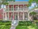 Inviting two-story home features a charming red exterior, double balconies, and a welcoming front porch at 715 Honeysuckle Ave, Celebration, FL 34747