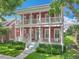 Inviting two-story home features a charming red exterior, double balconies, and a welcoming front porch at 715 Honeysuckle Ave, Celebration, FL 34747
