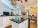Kitchen island features white cabinetry, black countertops, and a wine cooler at 715 Honeysuckle Ave, Celebration, FL 34747