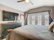 This main bedroom has a media center and a balcony with white plantation shutters at 715 Honeysuckle Ave, Celebration, FL 34747