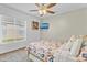 Bright bedroom features a ceiling fan, a mounted TV, and a window with natural light at 7830 Myrtle Oak Ln, Kissimmee, FL 34747