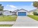 Charming single-story home with a well-manicured lawn and a blue garage door at 7830 Myrtle Oak Ln, Kissimmee, FL 34747