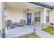 Charming front porch featuring seating area, plants, and a decorative blue front door at 7830 Myrtle Oak Ln, Kissimmee, FL 34747