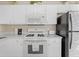 White kitchen offers modern appliances and white cabinets, providing a clean aesthetic at 7830 Myrtle Oak Ln, Kissimmee, FL 34747
