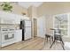 Bright kitchen features white cabinets, modern appliances, wood flooring, and charming breakfast table at 7830 Myrtle Oak Ln, Kissimmee, FL 34747