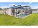 Screened pool features a covered patio and green grass in the backyard at 7830 Myrtle Oak Ln, Kissimmee, FL 34747
