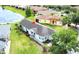 Aerial view of a home with a well-manicured lawn, mature trees and a charming, light-colored exterior at 817 Grand Canal Dr, Kissimmee, FL 34759