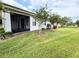 A screened lanai is pictured next to a verdant lawn and fresh plantings at 817 Grand Canal Dr, Kissimmee, FL 34759