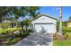 Charming home with a manicured front yard, paved driveway, and an attached garage at 817 Grand Canal Dr, Kissimmee, FL 34759