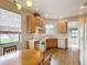 Cozy kitchen with wood cabinets, laminate floors, and an eat-in area with charming window coverings at 817 Grand Canal Dr, Kissimmee, FL 34759