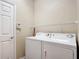 Functional laundry room with washer, dryer, and storage shelf at 817 Grand Canal Dr, Kissimmee, FL 34759