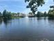 Scenic lake view with a water fountain, lush trees, and blue umbrellas in the background at 8369 Riverdale Ln # 1, Davenport, FL 33896