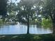 Scenic lake view with lush green trees and a fountain in the distance at 8369 Riverdale Ln # 1, Davenport, FL 33896