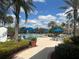Community pool featuring an in-ground pool, blue umbrellas, palm trees, and lounge chairs at 8369 Riverdale Ln # 1, Davenport, FL 33896