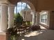 Covered porch with rocking chairs framed by elegant columns and shade at 8369 Riverdale Ln # 1, Davenport, FL 33896