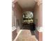 Exterior walkway with red brick and tan walls with a view of green shrubs at 8369 Riverdale Ln # 1, Davenport, FL 33896