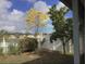 Scenic backyard view with flowering trees and a classic white picket fence at 954 Hacienda Cir, Kissimmee, FL 34741