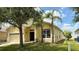 Attractive front exterior with palm trees, well-manicured lawn, and a two-car garage at 954 Hacienda Cir, Kissimmee, FL 34741