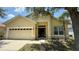 Charming single-Gathering home with a well-maintained lawn, two-car garage, and inviting front entrance at 954 Hacienda Cir, Kissimmee, FL 34741