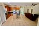 Open-concept kitchen with wood cabinets, black countertops, and an island, seamlessly flowing into the living area at 954 Hacienda Cir, Kissimmee, FL 34741
