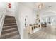 Bright and modern foyer with wood-look tile, staircase, and an arched entryway to the living area at 14314 Pleach St, Winter Garden, FL 34787