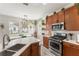 A cozy kitchen with stainless steel appliances, warm cabinetry, and abundant natural light at 14314 Pleach St, Winter Garden, FL 34787