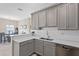 Modern kitchen featuring gray cabinets, white subway tile backsplash, and an open layout at 1000 Blackwolf Run Rd, Davenport, FL 33896