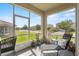 Screened-in porch with comfortable lounge seating offering a view of the neighborhood at 1000 Blackwolf Run Rd, Davenport, FL 33896