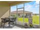 A screened-in porch featuring outdoor seating with a view of the backyard and the neighborhood at 1000 Blackwolf Run Rd, Davenport, FL 33896
