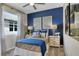 Cozy bedroom with a large window, blue accent wall, and stylish furnishings at 1003 Cloud Ridge Ct, Mount Dora, FL 32757