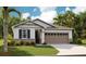 Charming single-story home featuring a two-car garage, stone accents, and well-manicured lawn at 1003 Cloud Ridge Ct, Mount Dora, FL 32757