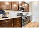 A kitchen with stainless steel appliances, stylish dark brown cabinets, and quartz countertops at 1003 Cloud Ridge Ct, Mount Dora, FL 32757